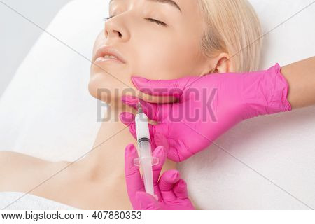 Cosmetologist Makes Lipolytic Injections To Burn Fat On The Chin, Cheeks And Neck Of A Woman Against