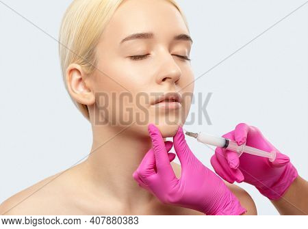 Cosmetologist Makes Lipolytic Injections To Burn Fat On The Chin, Cheeks And Neck Of A Woman Against