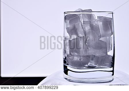 A Glass Full Of Ice Cubes Against A Glowing Led Lamp Close Up With A Copy Space. Counterlight