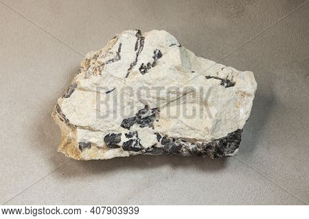 A Sample Of A Mineral Found In The Arctic On Dixon Island, On A Gray Background, Close-up.