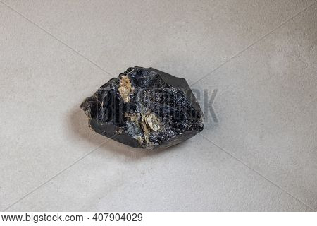 Stone, A Sample Of A Mineral Found In The Arctic,  Flint On A Gray Background, Close Up.