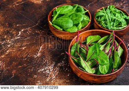 Mix Salad Leafs, Arugula, Spinach And Swiis Chard In Wooden Bowls. Dark Background. Top View. Copy S