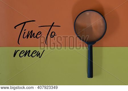 Top View Of Magnifying Glass Over Yellow And Orange Background With Text Time To Renew.
