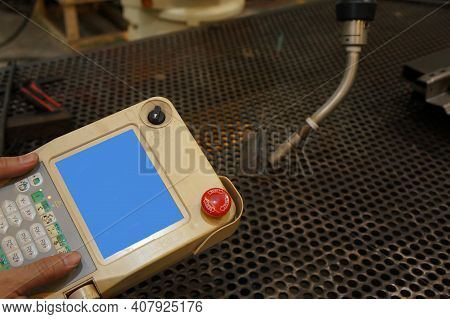 Hand Of The Engineers Are Using Remote Control Robotic Welding.
New Era In Automatic Manufacturing I