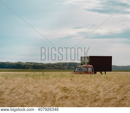 Vintage Red Truck Abandoned In Rural Area Among Wheat Field. Copy Space Advertisement