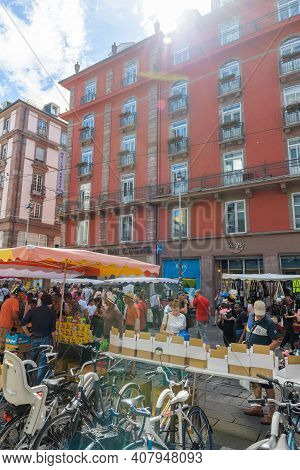 Strasbourg, France - July 29, 2017: Sunlight Flare Over Market Stall With Sellers And Customers Duri