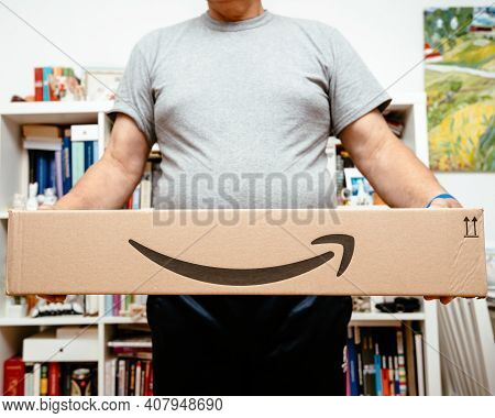 Paris, France - Oct 10, 2019: Lower Part Of Senior Man Smiling While Holding Two New Amazon Prime Pa
