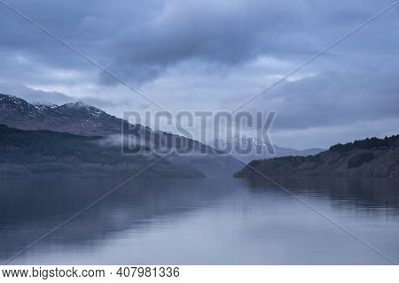 Beautiful Landscape Image Across Loch Lomond Looking Towards Snow Capped Ben Lui Mountain Peak In Sc