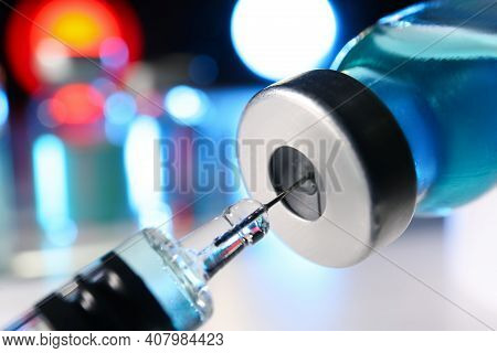 Filling Syringe With Vaccine From Vial On Blurred Background, Closeup