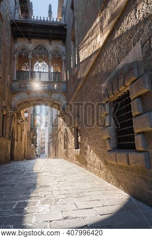 Arcelona, Spain - February 13 2021: The Iconic Old Style Bridge Of Carrer Del Bisbe During Morning