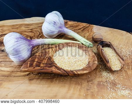 Dried Garlic Granules On Brown Olive Wood