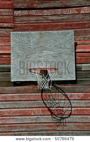 old basketball hoop hanging on a barn wall