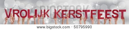 People Holding Vrolijk Kerstfeest On A Silver Background
