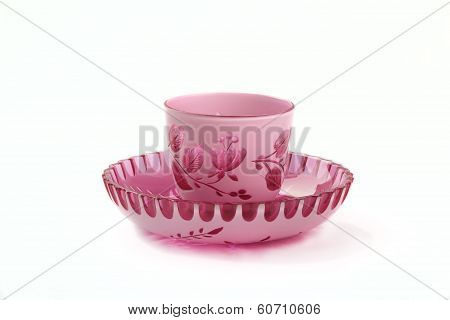 decorative pink and white colored clear crystal ornamental cup and saucer isolated on white backgrou