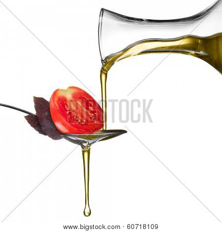 Pouring oil on spoon with basil and tomato isolated on white