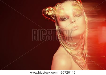 Art project: beautiful woman with golden make-up. Jewelry, make-up. Fashion. Light effects.