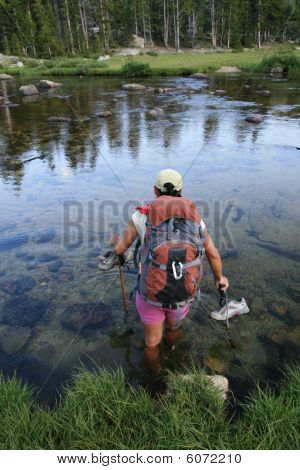 Kvinde Backpacker vadede over floden