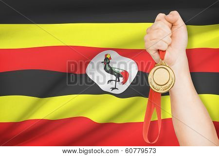 Medal In Hand With Flag On Background - Republic Of Uganda