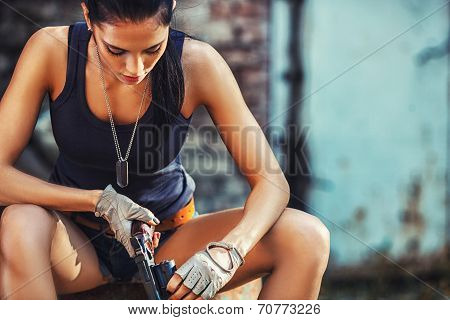 sexy brutal woman sitting and holding handgun