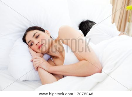 Huolissaan nainen makaa hänen Bed