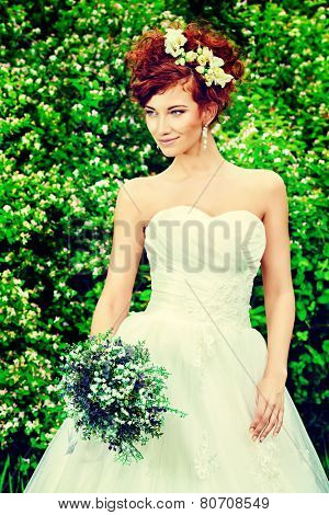 Beautiful smiling bride with chaming red hair. Wedding dress and accessories. Wedding decoration. 