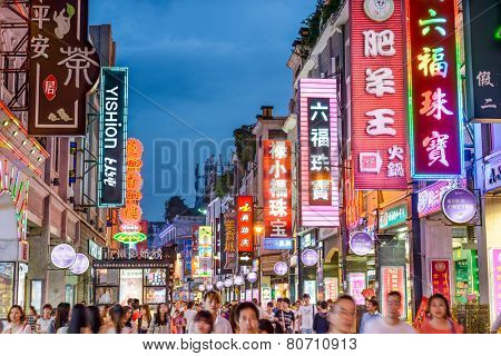 GUANGZHOU, CHINA - MAY 25, 2014: Pedestrians pass through Shangxiajiu Pedestrian Street. The street is the main shopping district of the city and a major tourist attraction.