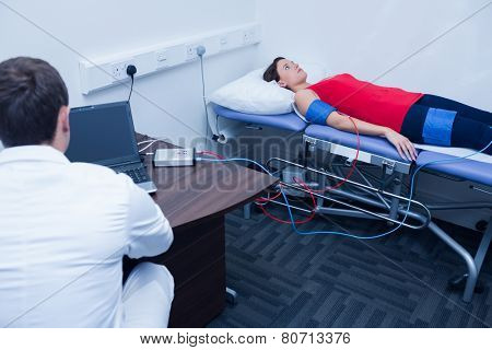 Doctor checking blood pressure of woman at medical office