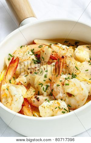 Garlic prawns in white serving pan.