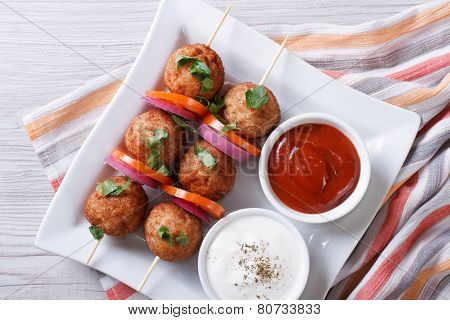 Meatballs On Skewers With Vegetables And Sauce Top View