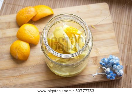 citrus in the glass jar on a wooden background