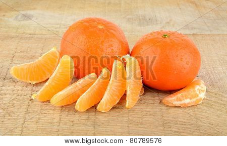 Mandarines With Pieces Isolated On Wooden Table