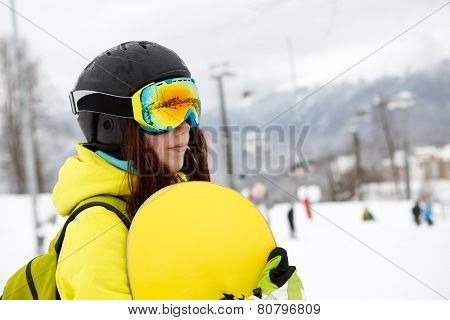 Smiling young gigl holding snowboard