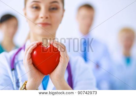 Female doctor with stethoscope holding heart .