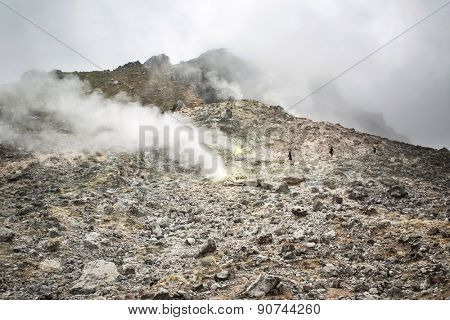 Berastagi, Indonesia - March 10, 2015: Tourists walking with a guide on Sibayak volcano near Berastagi in northern Sumatra, Indonesia