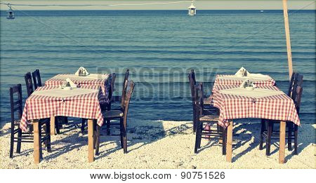 Dining table and chairs set outside on a beach - retro styled photo