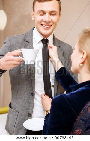 Woman fixing tie of handsome man