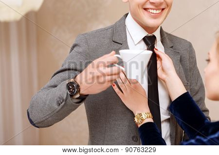 Woman fixing tie of handsome man