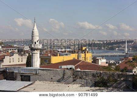 The minaret of a mosque Samani Virani and the Golden Horn metro bridge. Istanbul. Turkey.