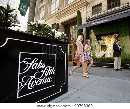NEW YORK CITY - FRIDAY, MAY 8, 2015: Pedestrians walk past Saks Fifth Avenue in Manhattan. Saks Fifth Avenue is an American department store chain owned by the Hudson's Bay Company.
