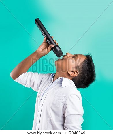 young indian boy in white shirt yelling in microphone, little kid singing, Little indian boy with mi