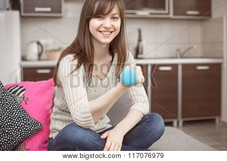 Smiling Woman Exercising With Hantel On Sofa