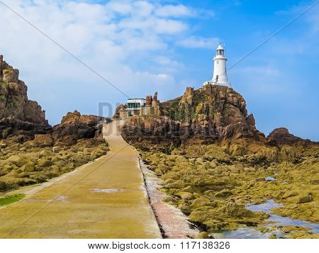 La Corbiere Lighthouse On The Rocky Coast Of Jersey Island