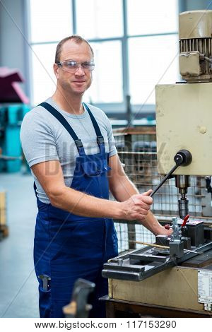 worker in factory using drill machine