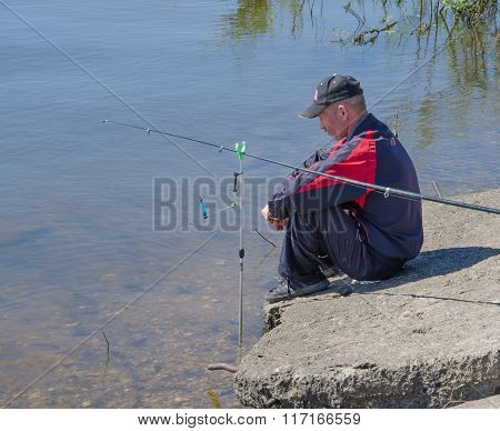 The Fisherman Sits By The River.