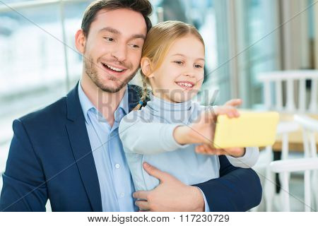Smiling good-looking father with daughter posing for picture.