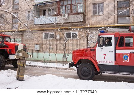 Firefighter Looking At An Apartment Building, Near A Fire Service, There Are Two Machines