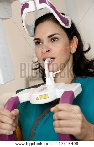 Closeup photo of young woman in dental panoramic x-ray room.