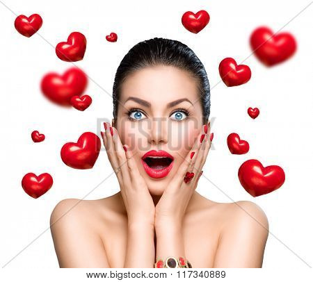 Beauty Fashion surprised Woman with flying red hearts. Love concept, Valentine's Day. Beautiful model girl with perfect make up exited and open and mouth. Isolated on a white background