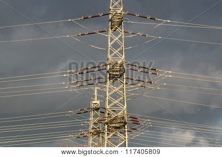 high-voltage electricity pylons against rain clouds