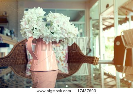 White Plastic Flowers In Pink Flower Vase On The Rattan Weave Table Decorated Interior In Cafe